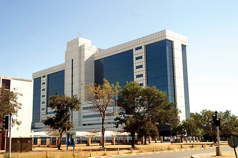 Modern building with blue glass windows and trees in Botswana